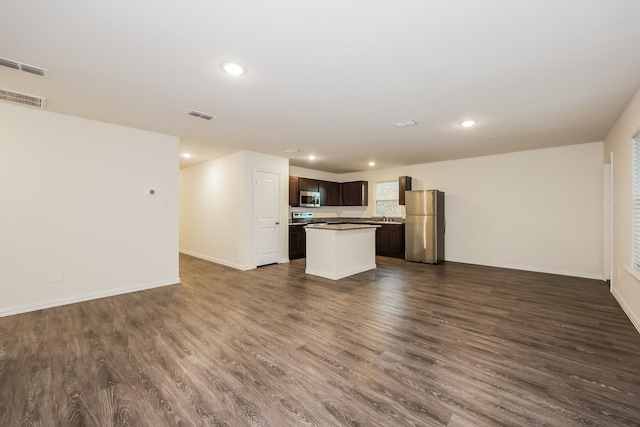 unfurnished living room with visible vents, dark wood-style flooring, and baseboards