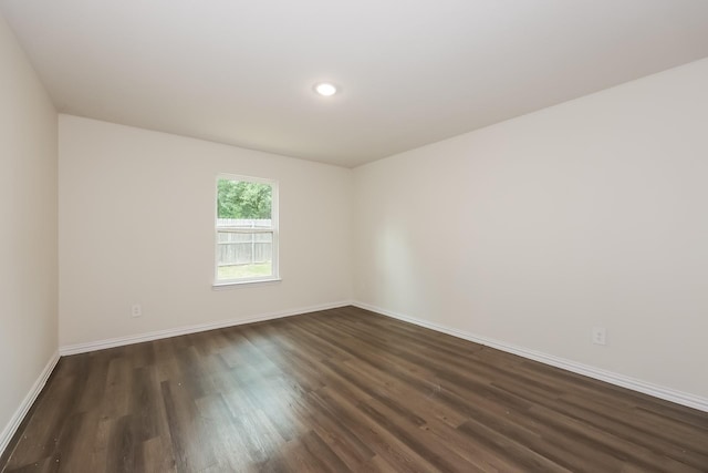 empty room featuring dark wood-style floors, recessed lighting, and baseboards