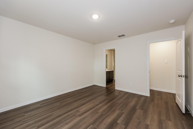 spare room featuring recessed lighting, visible vents, dark wood-style flooring, and baseboards