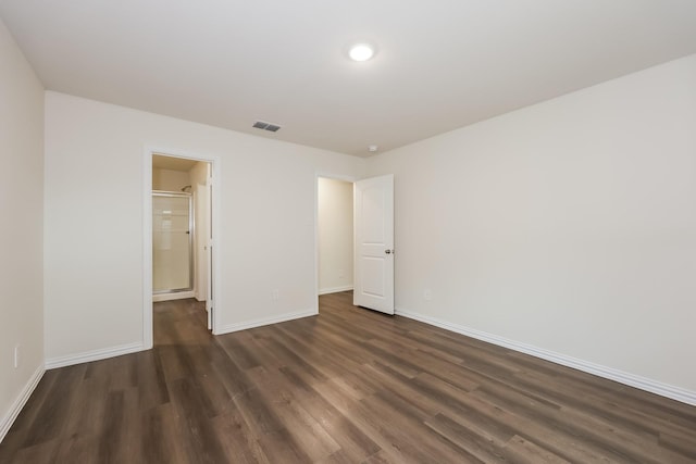 unfurnished bedroom featuring visible vents, dark wood-style flooring, and baseboards