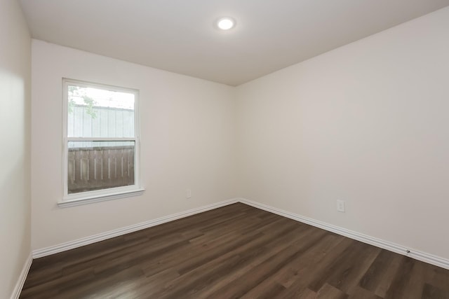 empty room featuring dark wood-type flooring, recessed lighting, and baseboards