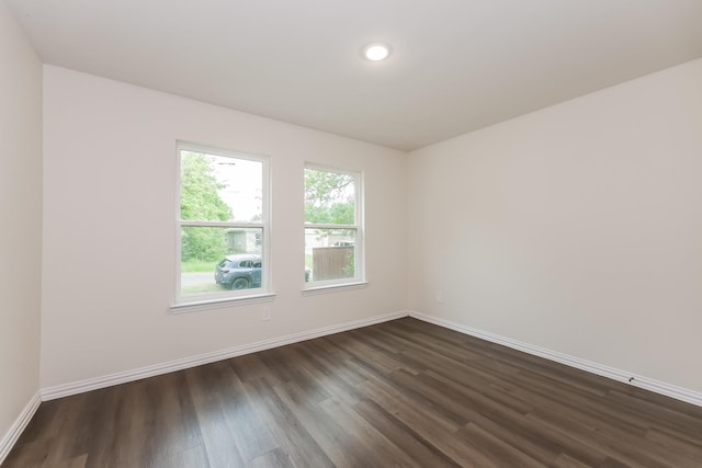spare room with dark wood-style floors, recessed lighting, and baseboards