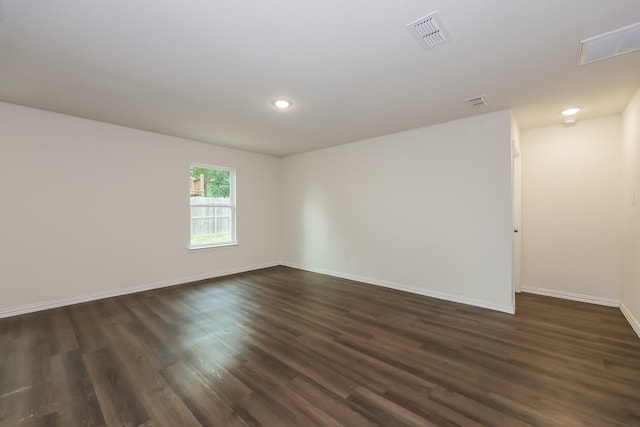unfurnished room with visible vents, recessed lighting, dark wood-style floors, and baseboards