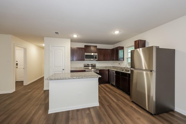kitchen with a center island, dark brown cabinetry, stainless steel appliances, and dark wood-type flooring