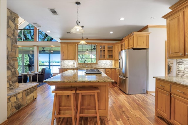 kitchen featuring visible vents, decorative backsplash, washer / dryer, and appliances with stainless steel finishes