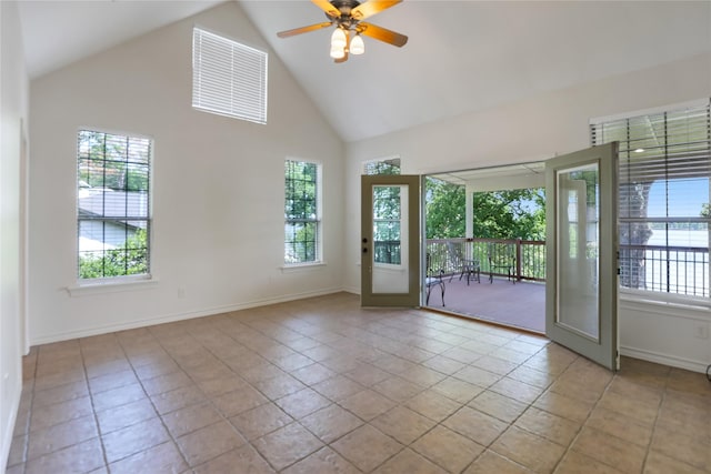 spare room with baseboards, ceiling fan, and high vaulted ceiling