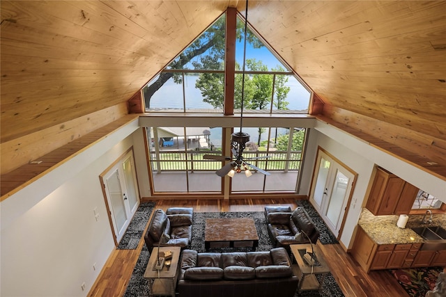 living area with wood finished floors, high vaulted ceiling, and wooden ceiling