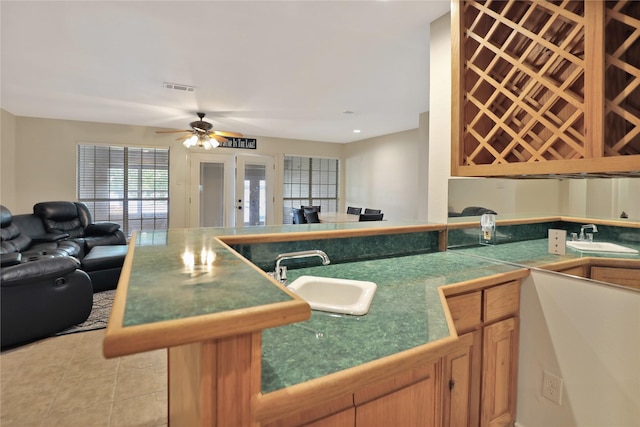 kitchen featuring a sink, ceiling fan, open floor plan, and visible vents