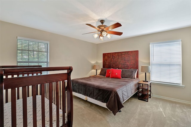 bedroom featuring baseboards, multiple windows, carpet, and ceiling fan