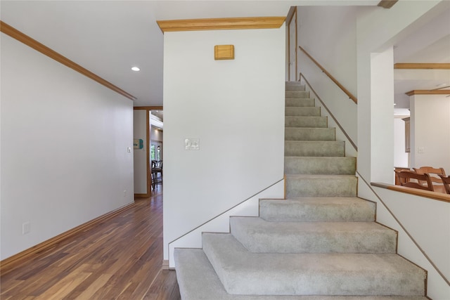 stairs with crown molding, baseboards, recessed lighting, and wood finished floors