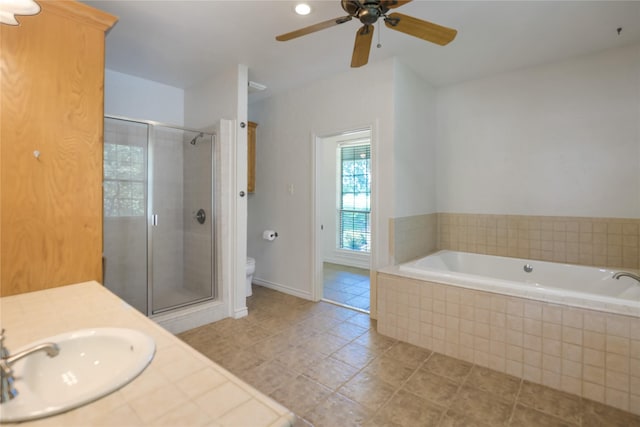 full bathroom featuring a garden tub, toilet, tile patterned floors, a shower stall, and a ceiling fan