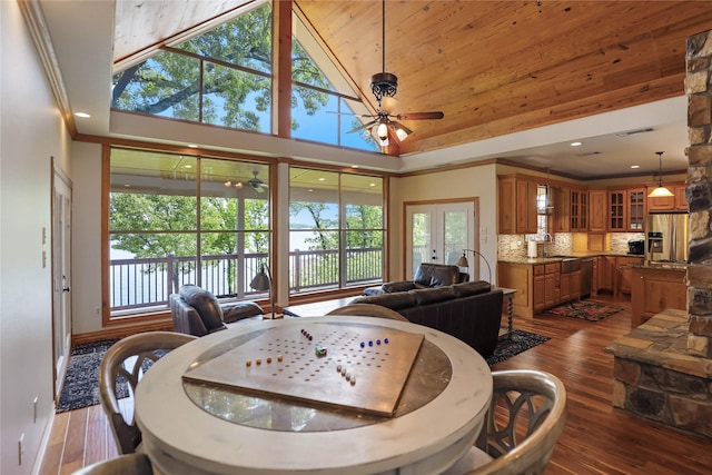 dining room featuring high vaulted ceiling, a ceiling fan, baseboards, visible vents, and dark wood-style floors