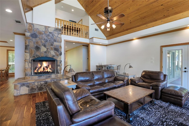 living room featuring visible vents, wood finished floors, a stone fireplace, high vaulted ceiling, and a ceiling fan