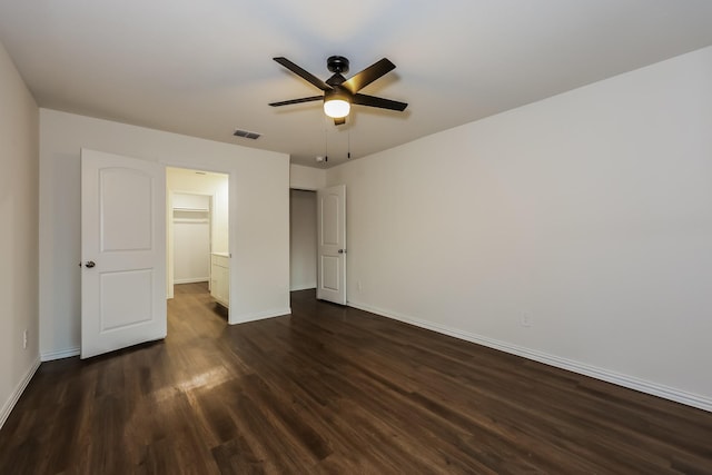 unfurnished bedroom with ceiling fan, baseboards, visible vents, and dark wood finished floors