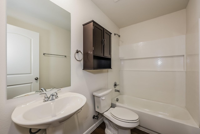 full bathroom with a sink, washtub / shower combination, baseboards, and toilet