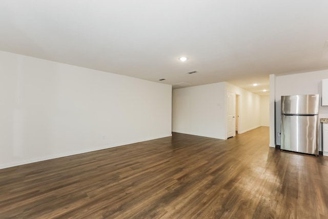 unfurnished living room with recessed lighting, baseboards, visible vents, and dark wood-type flooring