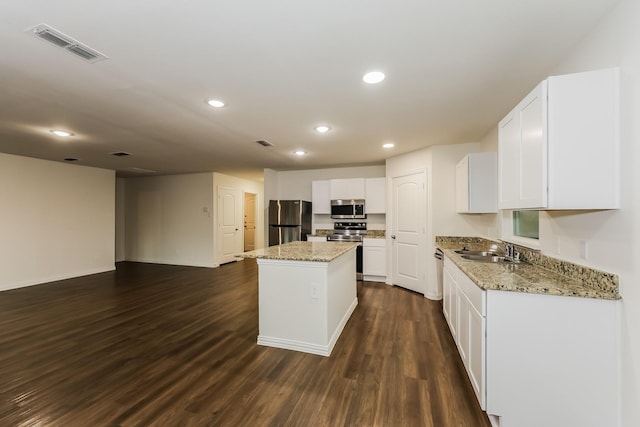 kitchen featuring a center island, dark wood-type flooring, white cabinetry, a sink, and stainless steel appliances