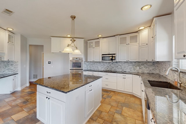 2609 Comanche Moon Dr, Fort Worth, TX 76179 - kitchen featuring visible vents, a sink, stone finish flooring, and stainless steel microwave