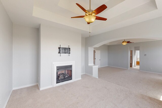 2609 Comanche Moon Dr, Fort Worth, TX 76179 - unfurnished living room featuring light colored carpet, arched walkways, ceiling fan, and a fireplace