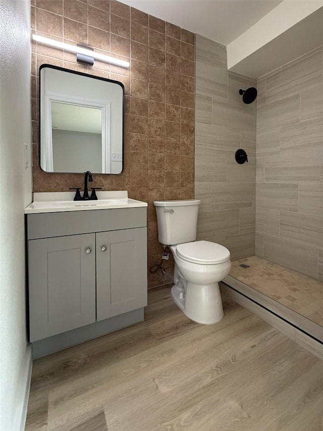 1830 Bosque Dr, Garland, TX 75040 - full bathroom featuring a tile shower, vanity, and wood finished floors