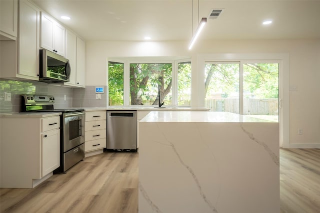 1830 Bosque Dr, Garland, TX 75040 - kitchen with stainless steel appliances, healthy amount of natural light, light wood-type flooring, light stone countertops, and recessed lighting