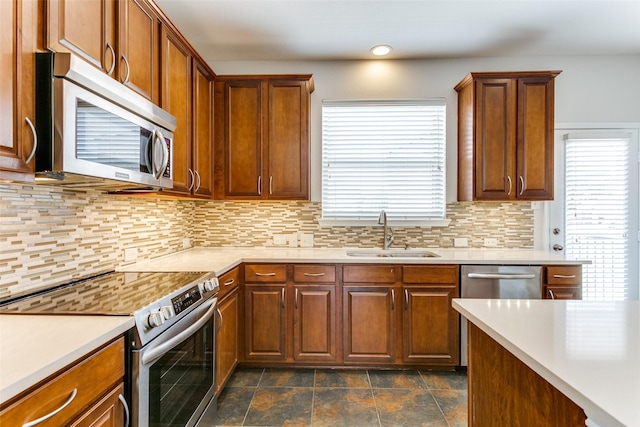 kitchen with light countertops, stainless steel appliances, plenty of natural light, and a sink