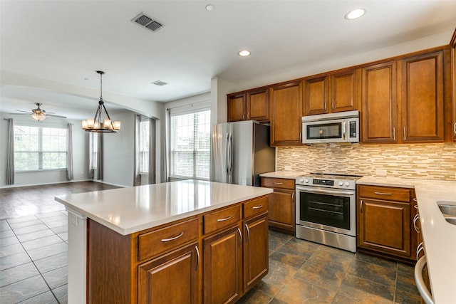 kitchen featuring visible vents, a healthy amount of sunlight, appliances with stainless steel finishes, and brown cabinetry