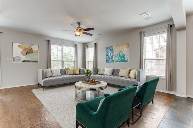 living room featuring visible vents, ceiling fan, and baseboards