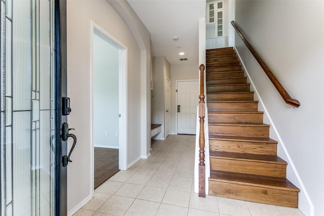 foyer with light tile patterned floors, visible vents, baseboards, recessed lighting, and stairs
