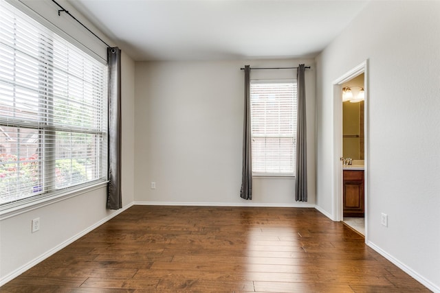 spare room with dark wood finished floors and baseboards