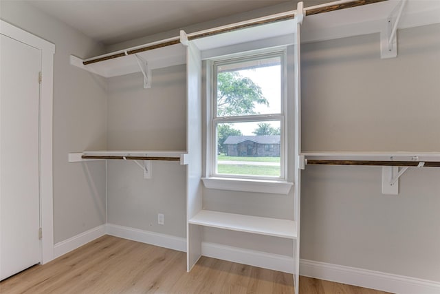 walk in closet with wood finished floors