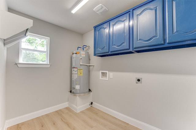 clothes washing area with hookup for an electric dryer, washer hookup, light wood-style flooring, water heater, and cabinet space