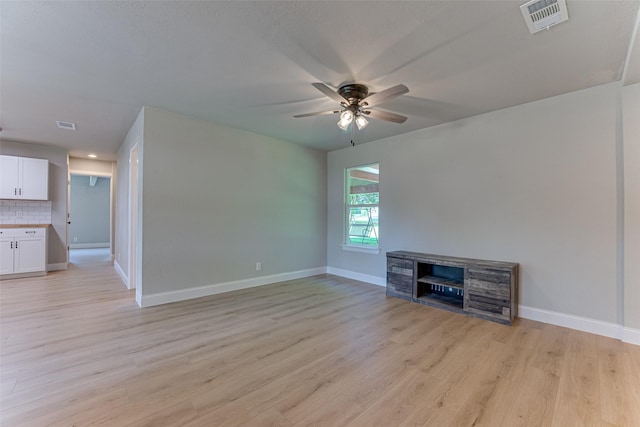 unfurnished living room with light wood finished floors, a ceiling fan, visible vents, and baseboards