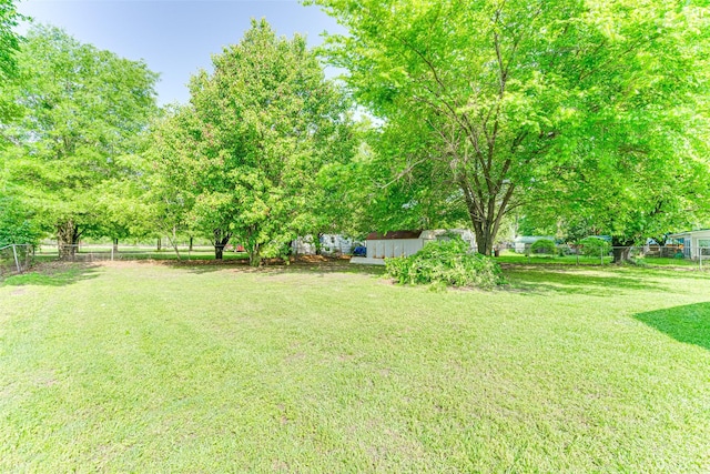 view of yard with fence and an outbuilding