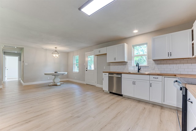 kitchen with a sink, wood counters, stainless steel appliances, and decorative backsplash
