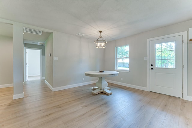 unfurnished dining area featuring light wood finished floors, visible vents, and baseboards