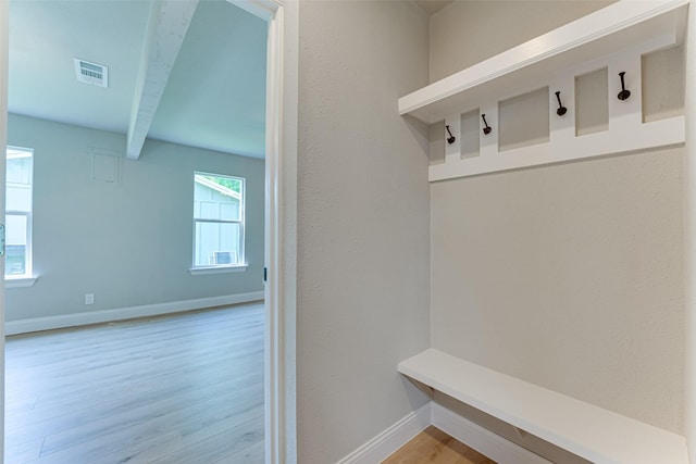 mudroom featuring visible vents, light wood-type flooring, beamed ceiling, and baseboards