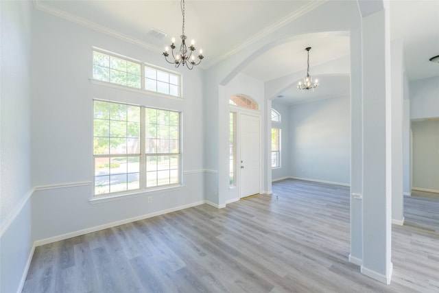 7404 Maybrook Ct, Plano, TX 75024 - foyer with a chandelier, arched walkways, crown molding, baseboards, and wood finished floors