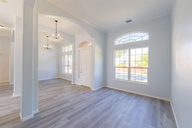 7404 Maybrook Ct, Plano, TX 75024 - entryway with arched walkways, wood finished floors, baseboards, ornamental molding, and a chandelier