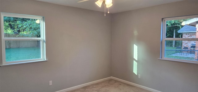 carpeted spare room with baseboards and a ceiling fan