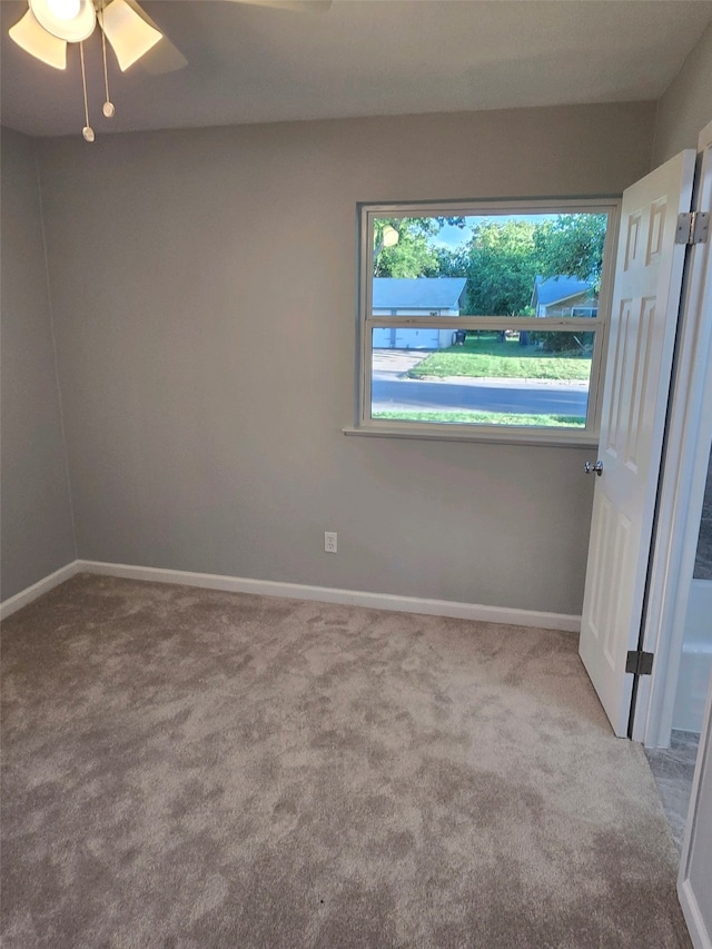 spare room with a ceiling fan, carpet floors, and baseboards