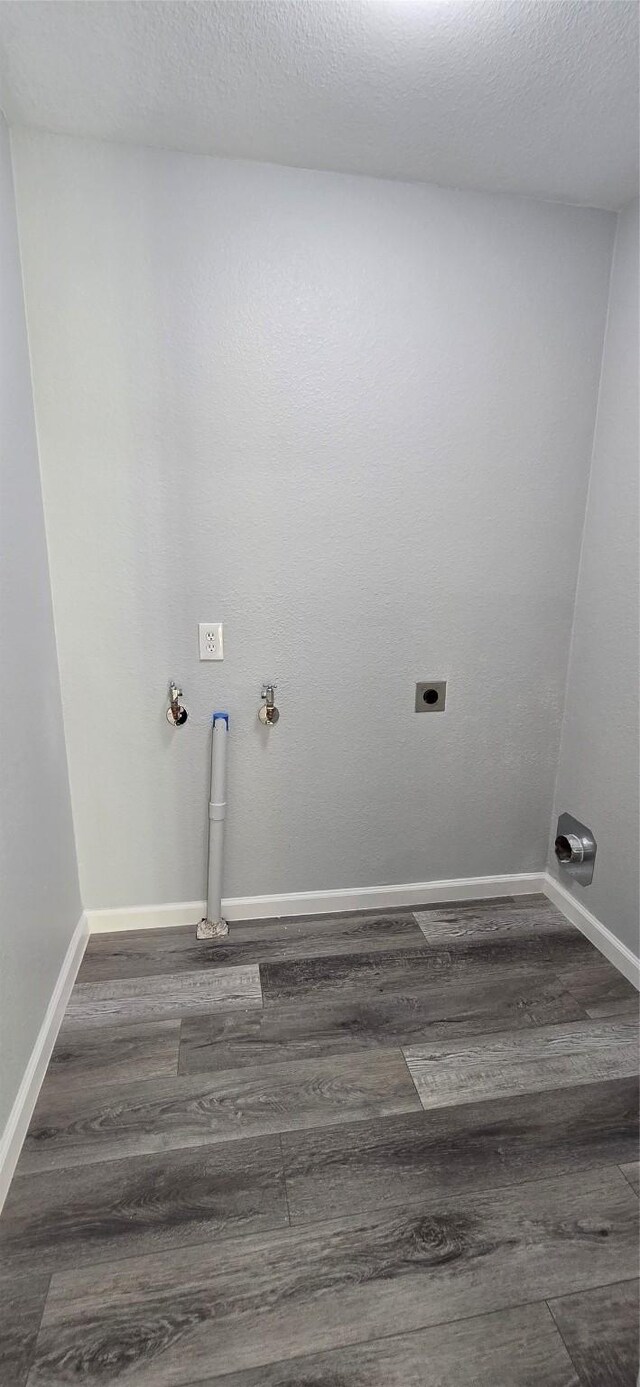 clothes washing area featuring hookup for an electric dryer, hookup for a gas dryer, baseboards, wood finished floors, and laundry area