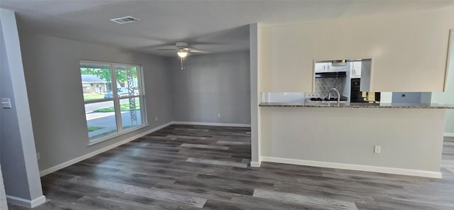 interior space featuring visible vents, white cabinets, ceiling fan, and dark wood-type flooring