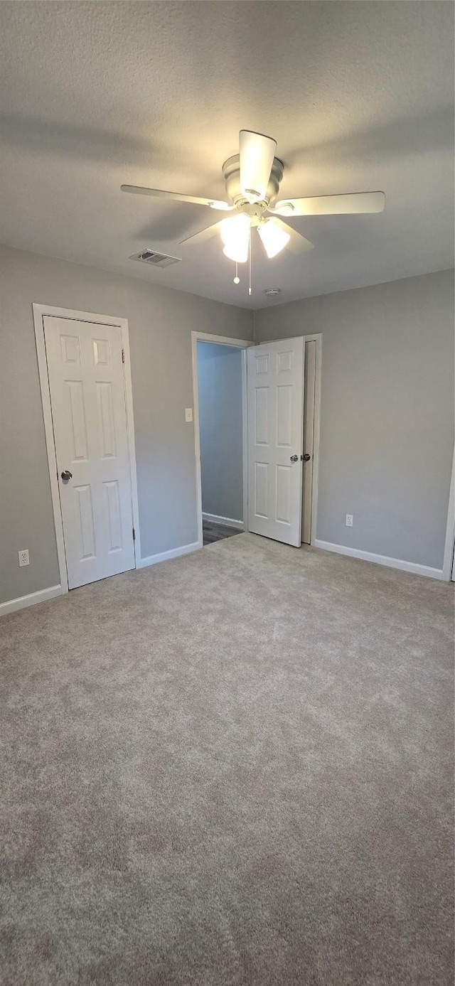 unfurnished bedroom with carpet floors, a textured ceiling, and baseboards
