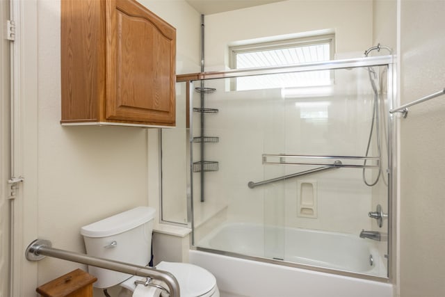 bathroom with bath / shower combo with glass door and toilet