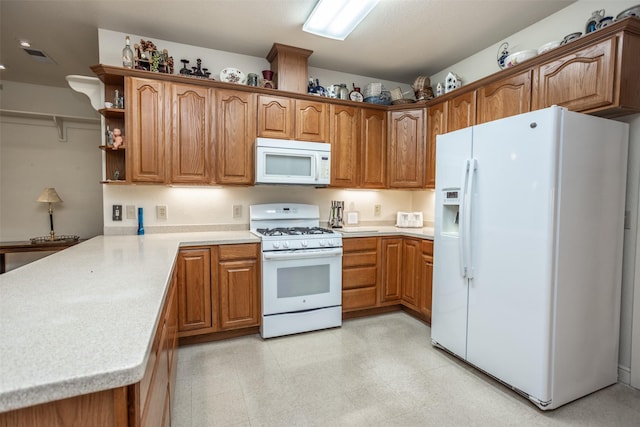 kitchen featuring brown cabinets, white appliances, light countertops, and a peninsula