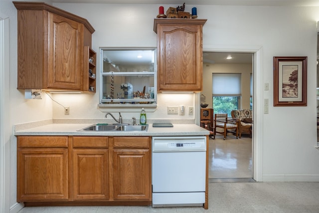 kitchen featuring a sink, brown cabinets, light countertops, and white dishwasher
