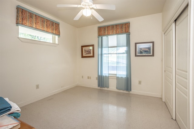 unfurnished bedroom with baseboards, ceiling fan, and a closet