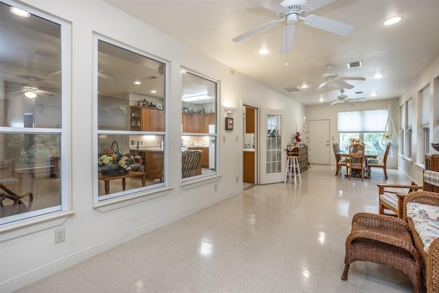 living room featuring baseboards, visible vents, a ceiling fan, and recessed lighting