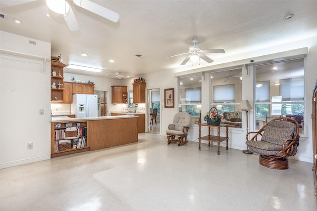 living area featuring ceiling fan, visible vents, and baseboards